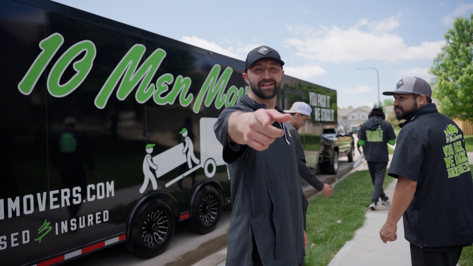A 10 Men Movers crew leader in front of a branded moving truck