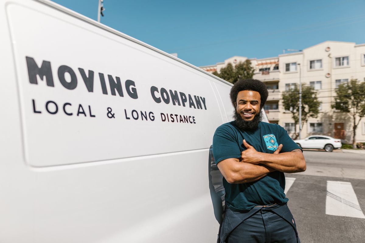 A mover standing in front of a moving van for a long-distance move